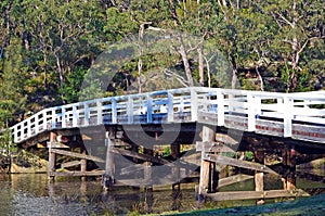 Wooden rustic bridge over river in forest