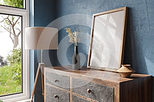 wooden rustic dresser wardrobe standing in petrol blue room corner bright daylight from large window empty mock up poster frame