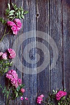 Wooden rustic old table texture with foliage frame and pink flowers