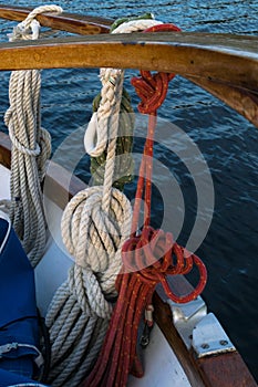 Wooden sailboat on the blue mediterranean sea. ropes, knots and wood plank on deck background.