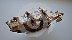 Wooden sailboat scale model with fabric sails and thread ropes top view