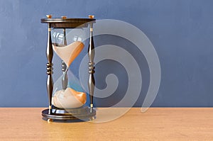 Wooden Sand Timer Hourglasses on the wooden table. 3D rendering