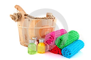 Wooden sauna bucket with colorful towels and soap