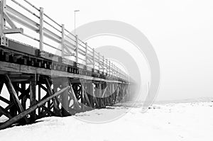 Wooden scary bridge disappearing in the fog. Bridge leading to nowhere. photo