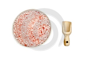 Wooden scoop, bowl full of bath salts with pink and white grains
