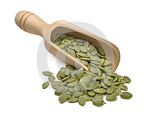 Wooden scoop with green pumpkin seeds isolated on white background