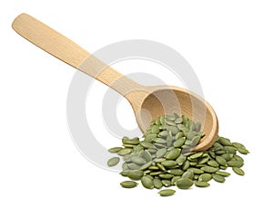 Wooden scoop with green pumpkin seeds isolated on white background. Diagonal layout