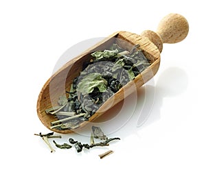 Wooden scoop with green tea and mint