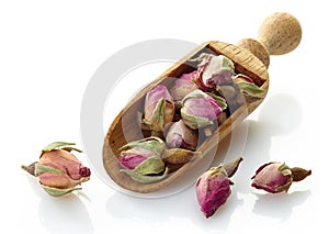 Wooden scoop with rose buds tea
