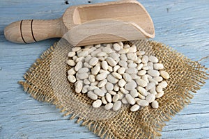 Wooden scoop with white beans