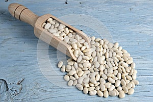 Wooden scoop with white beans