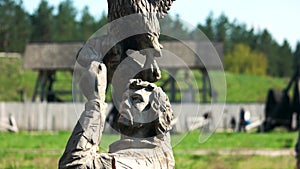 Wooden sculpture of man holding hawk bird.