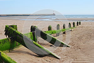 Wooden sea barrier at Spittal and lighthouse