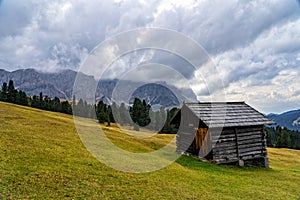 Wooden shed on a grassy meadow in a mountains