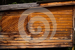 Wooden shed made of slats with a door.