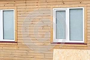 A wooden sheet of plywood for closing the windows lies next to the house