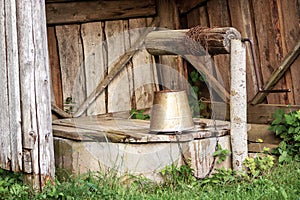 A wooden shelter for a water well site with a bucket