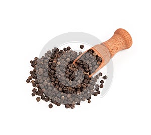 Wooden shovel with black peppercorn scattered from it