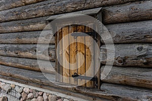 Wooden shutter on forged hinges under the visor. ancient Russian architecture