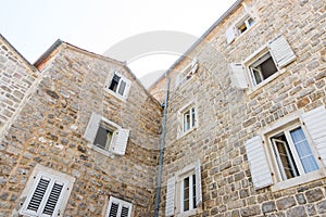 Wooden shutters on a stone wall of the house in the old Budva, Montenegro