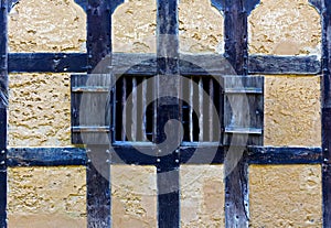 Wooden shutters in the wall of old adobe house