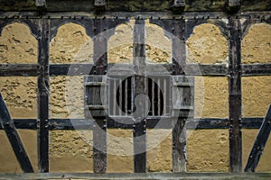 Wooden shutters in the wall of an old adobe house