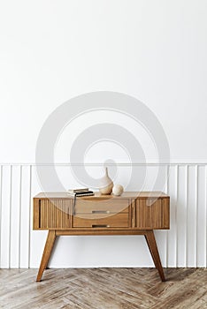 Wooden sideboard table with books and a vase