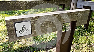 Wooden sign of bike bicycle parking place on park forest background