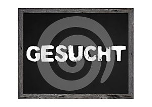 Wooden sign or chalkboard showing: Wanted with white letters in german language