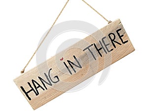 Wooden sign hang in there hanging on stone wall with heart as do photo