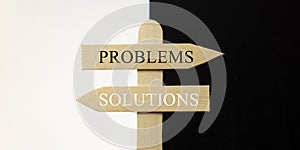 Wooden sign with the words problems and solutions photo