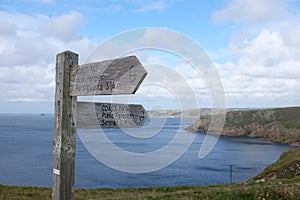 Wooden sign pointing the way along the dramatic clifftops of the coast path, Pembrokeshire, Wales