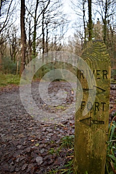 Wooden sign post indicating the directions to a river and a fort
