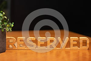 Wooden sign Reserved on the table in the restaurant. Restaurant reserved table sign with places setting