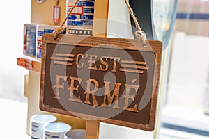 Wooden sign shop panel write in french c`est fermÃ© means store is closed now