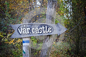 Wooden sign to the castle in Hungary in autumn park