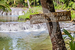 Wooden sign Tourist is not allowed this area at Cambugahay Falls on Siquijor island, Philippine