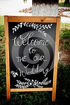 A wooden sign with a wedding invitation for holiday guests. Creative image for your design