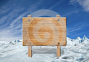 Wooden sign on winter landscape.