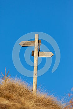 Wooden signpost and blue sky.