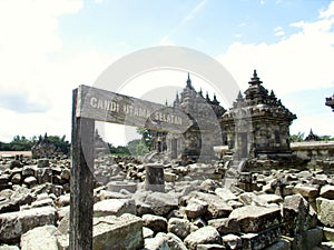 Wooden Signpost board to Main South Temple of Plaosan Temple Candi, Klaten, Indonesia stone rocks ruins background landscape