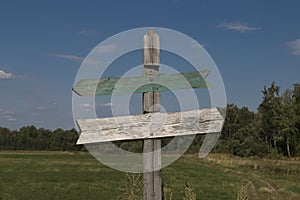 Wooden signpost at the crossroads with two arrows