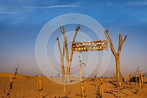 A wooden signpost at the entrance of Love Lake Dubai