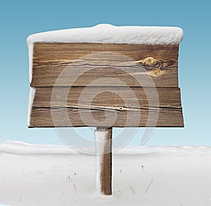 Wooden signpost with less snow and blue sky