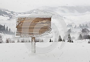 Wooden signpost with snow and mountains