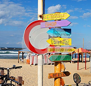 Wooden signpost on sunny beach. Seascape with lovely blue sky