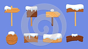 Wooden signs and snow caps. Winter wood arrows, banners and symbols under snowy. Decorative village elements, isolated