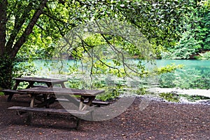 Wooden sitting bench by a lake surrounded by forest in Yedigoller National Park Turkey