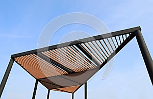 Wooden slats roof with blue sky background.