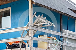 Wooden sledge resting on wooden veranda of blue house in Maniitsoq, Greenland